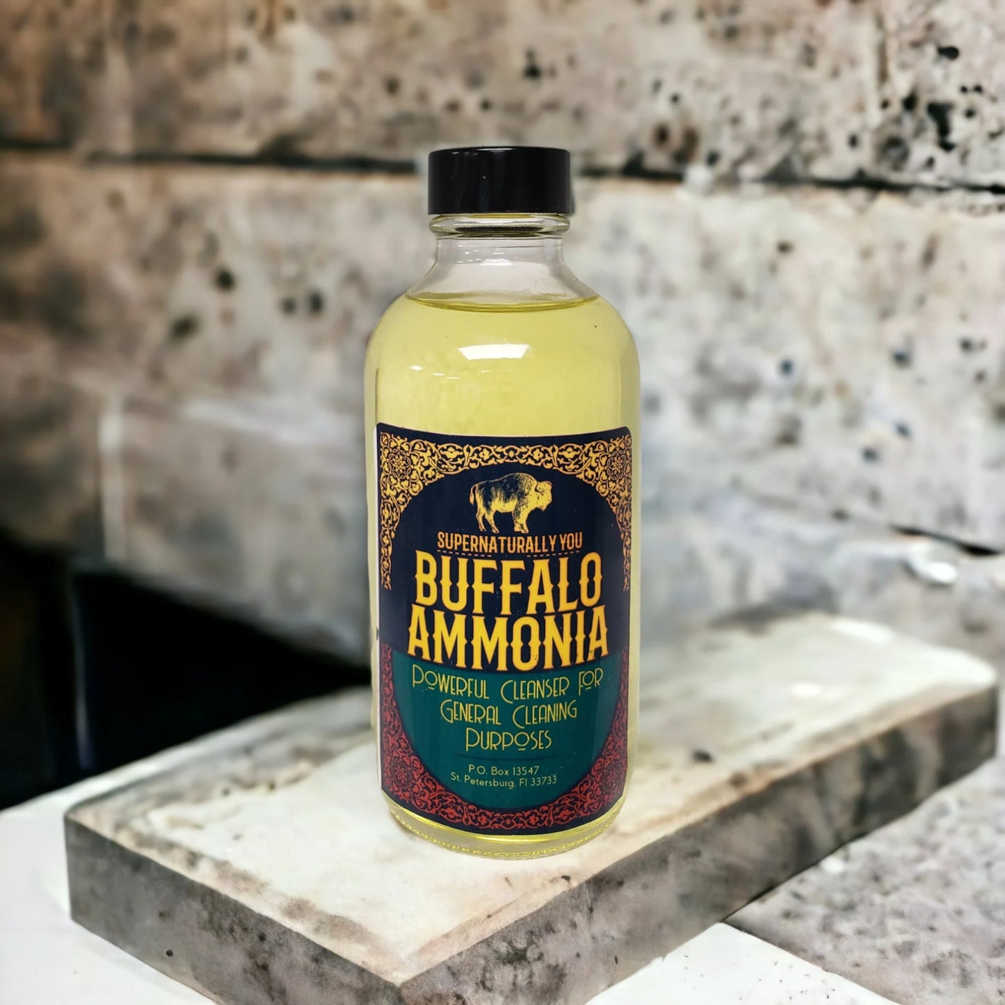 A bottle labeled "Buffalo Ammonia" for general cleaning purposes sits on a concrete or stone surface.