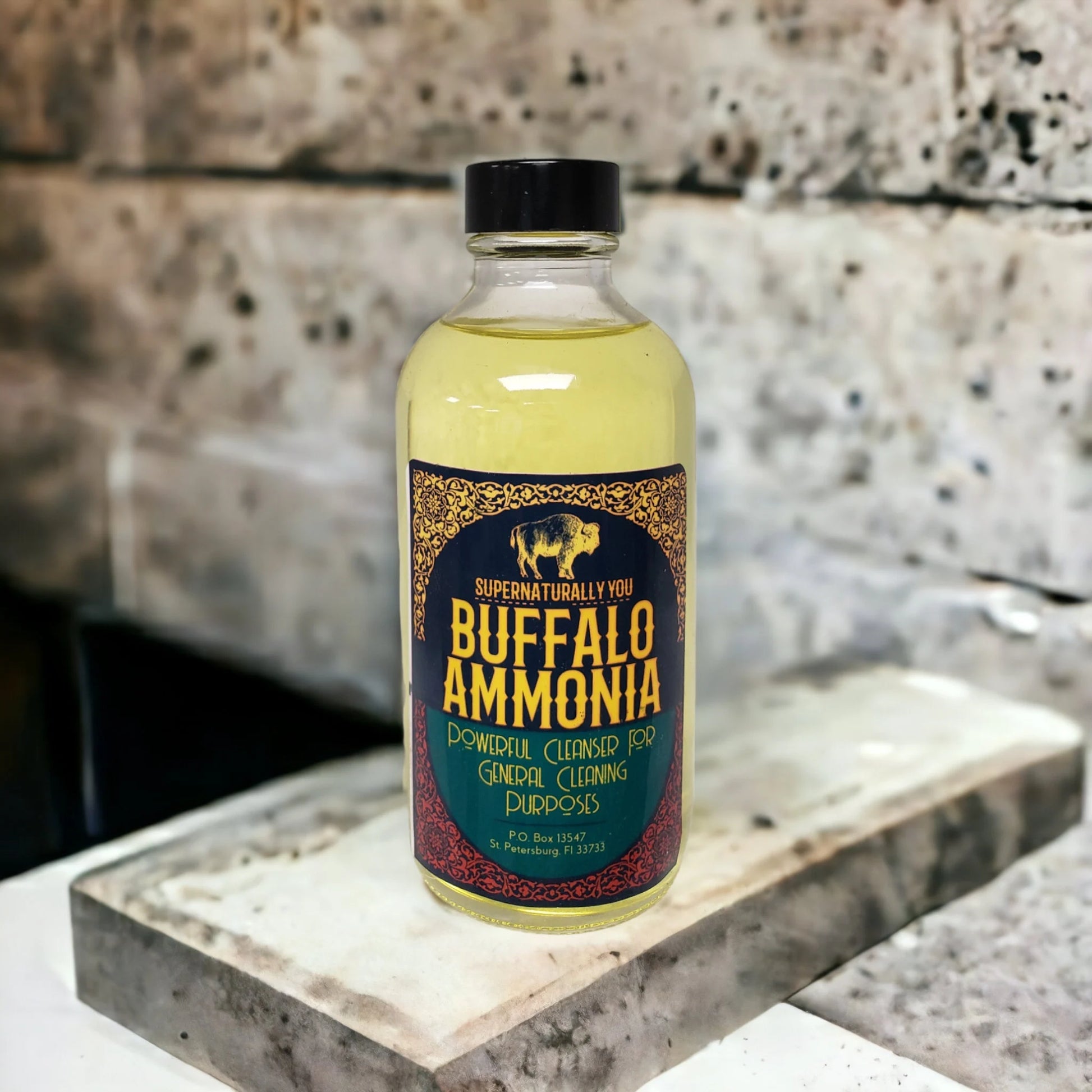 A bottle labeled "Buffalo Ammonia" for general cleaning purposes sits on a concrete or stone surface.